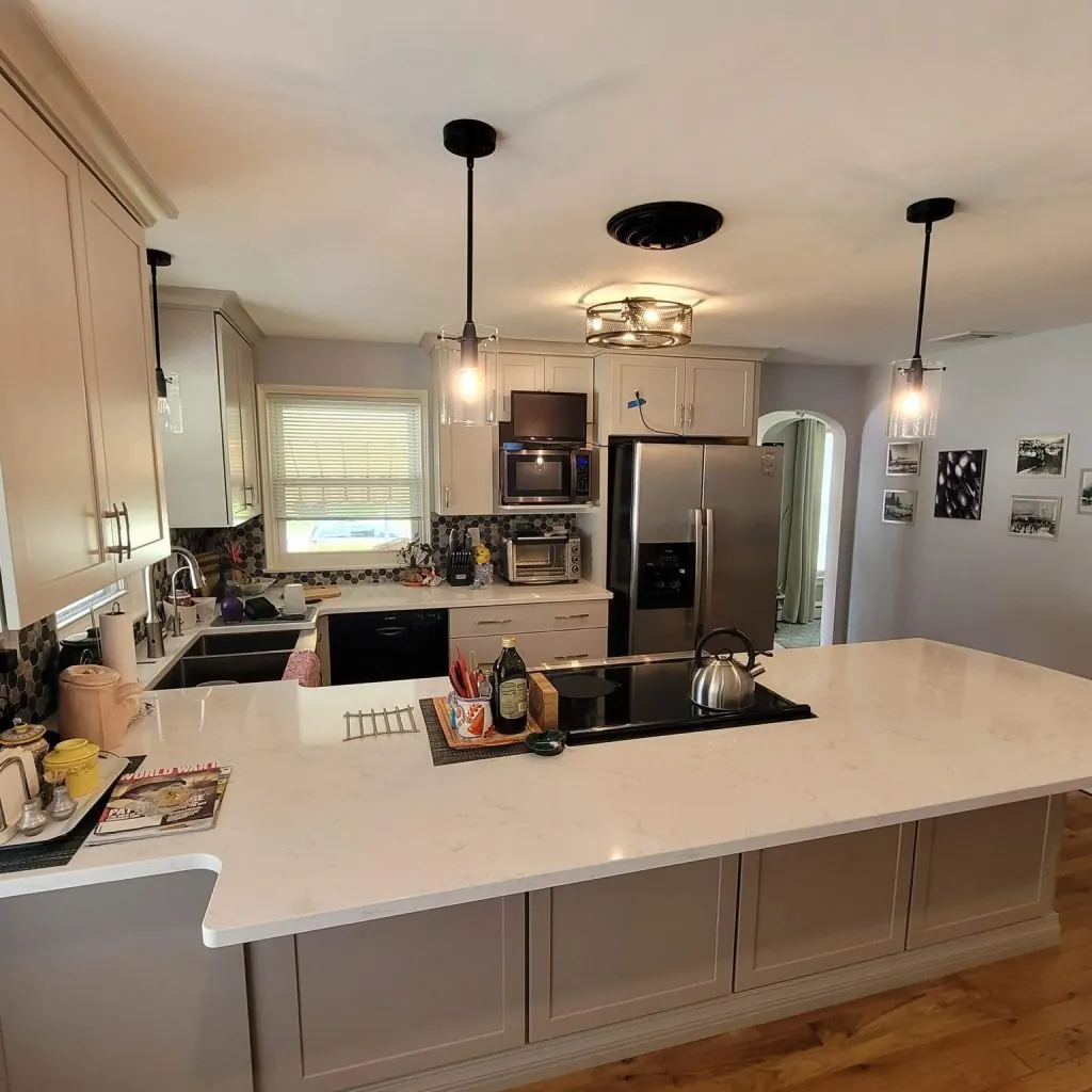 Open kitchen with large quartz peninsula and cream shaker cabinets
